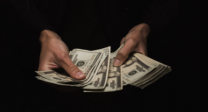 A person holding a stack of money